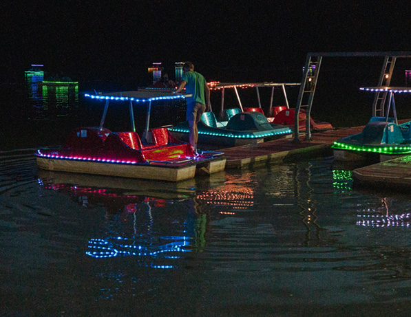 a man standing on a dock with lights on it