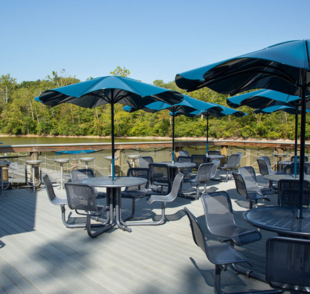 a group of tables and chairs on a deck with umbrellas