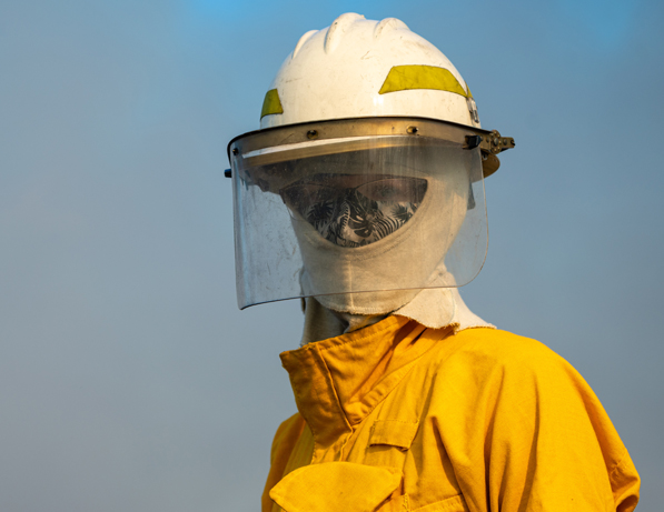 a person wearing a yellow uniform and face shield