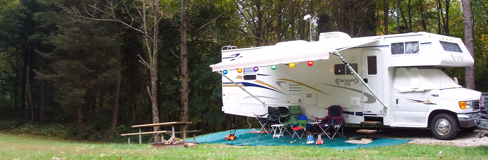 a camper with a picnic table and chairs