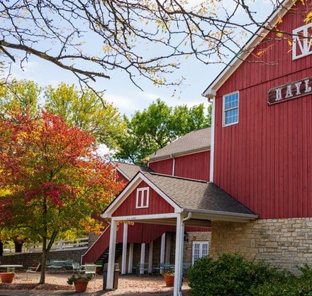 a red barn with trees and a white canopy