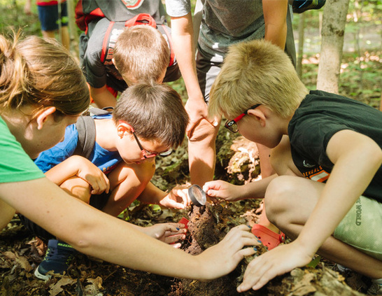 a group of kids looking at a magnifying glass