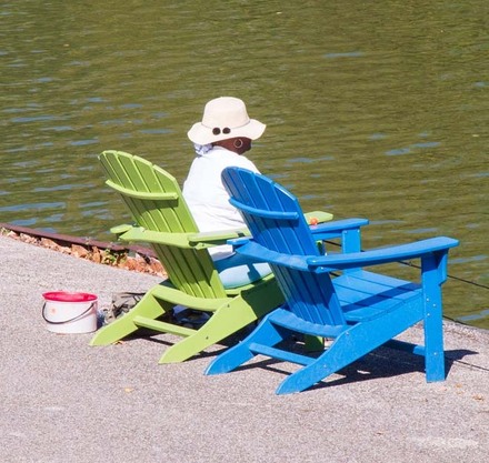 a person sitting in a chair next to a body of water