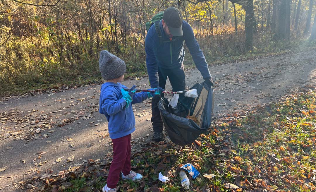 a man and child picking up trash
