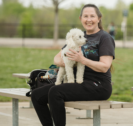 a woman sitting on a bench holding a dog