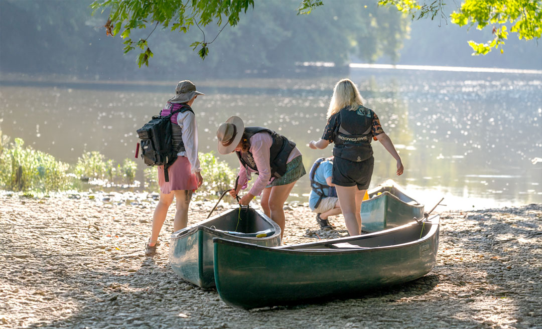 a group of people standing next to a row of boats