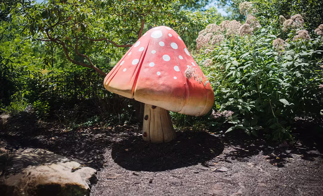 a mushroom shaped statue in a garden