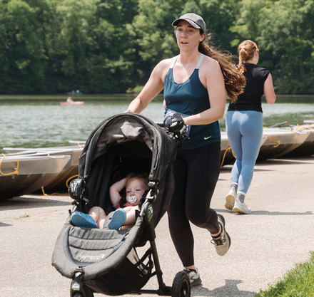a woman running with a baby in a stroller