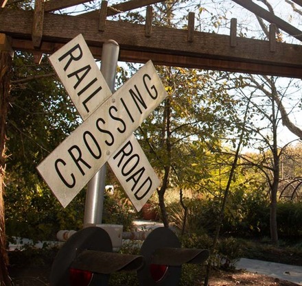 a railroad crossing sign in a garden