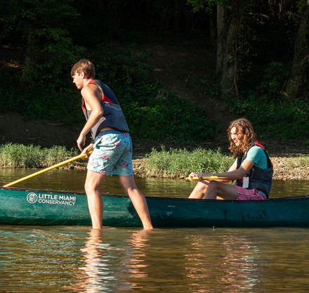 two boys in a canoe on a river