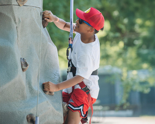 a boy climbing a rock wall