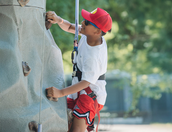 a boy climbing a rock wall