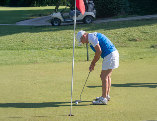 a woman playing golf on a golf course