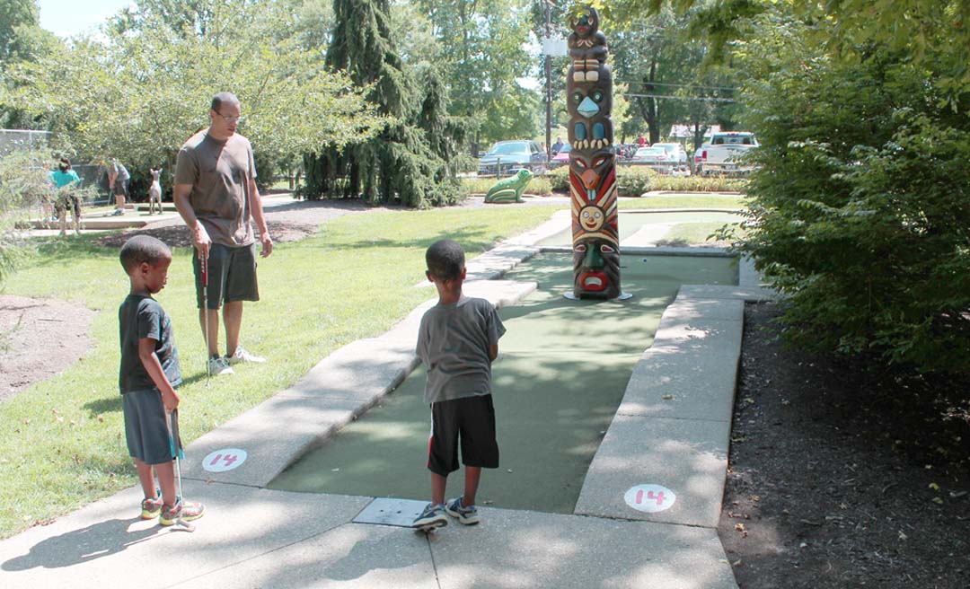 a boy playing mini golf