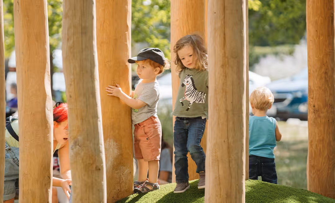 a group of kids standing on a wooden structure