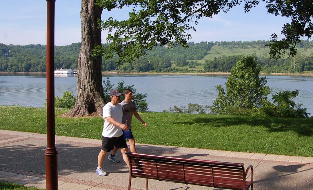 two men walking on a path near a lake