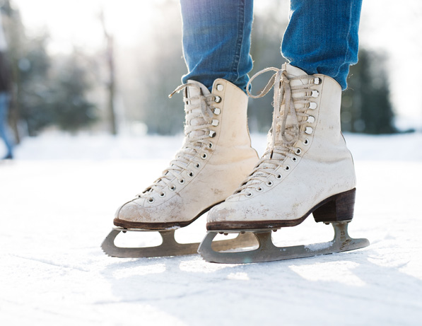 a person's feet wearing white ice skates