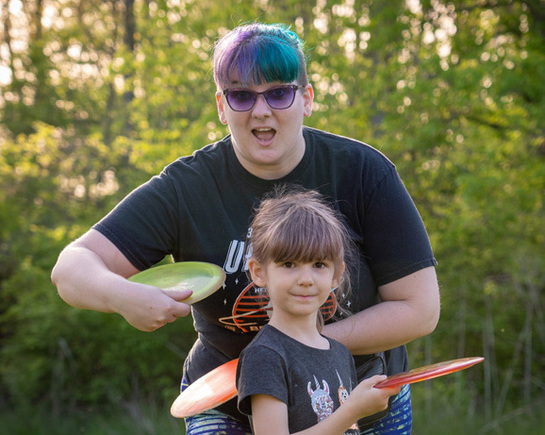 a woman and a girl holding frisbees