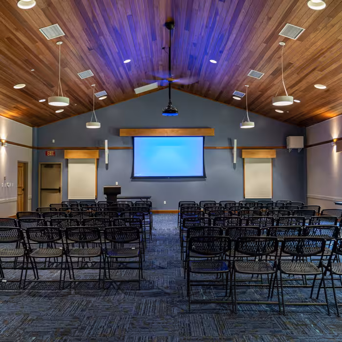 a room with chairs and a projector screen
