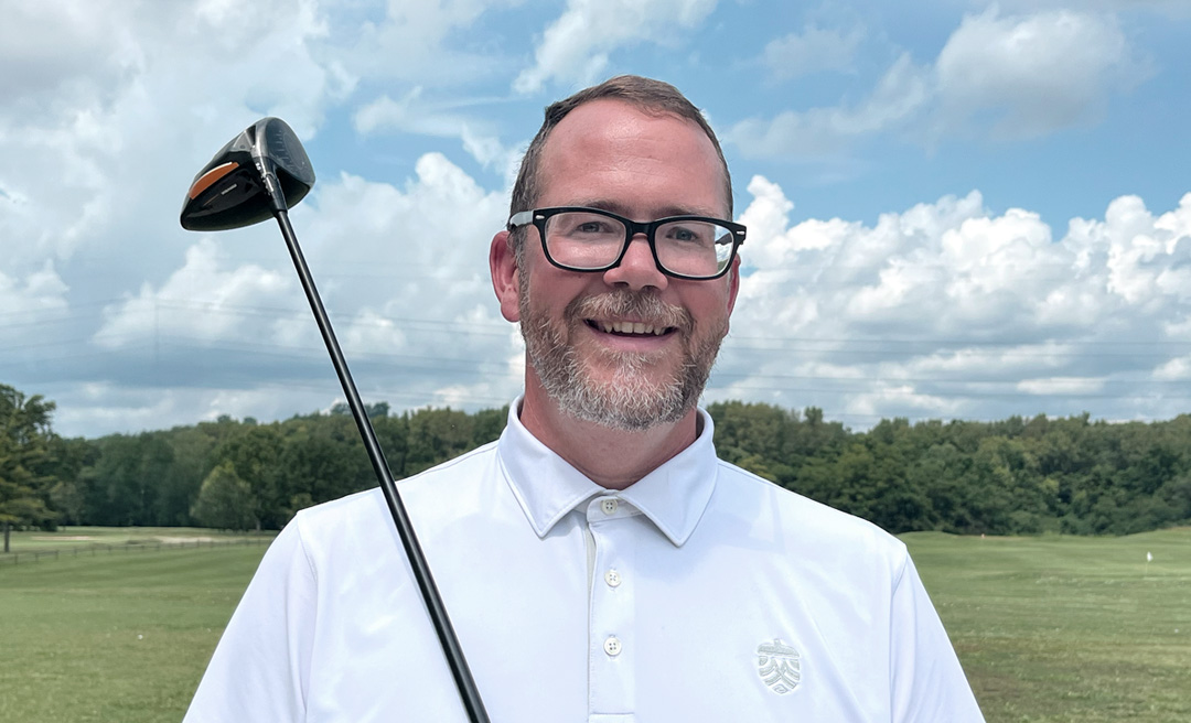 a man in glasses holding a golf club
