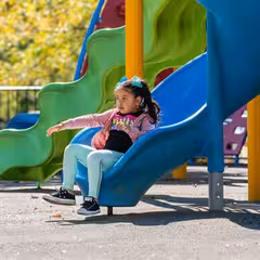 a girl sitting on a slide
