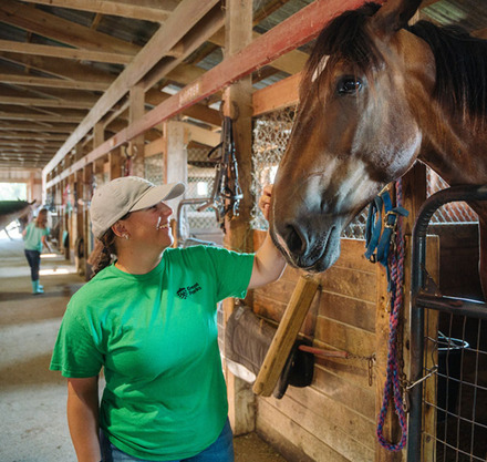 a woman petting a horse