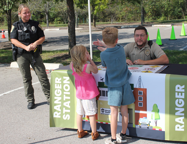 a man and two kids at a table with a police officer