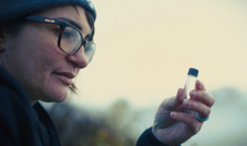 a woman holding a small container