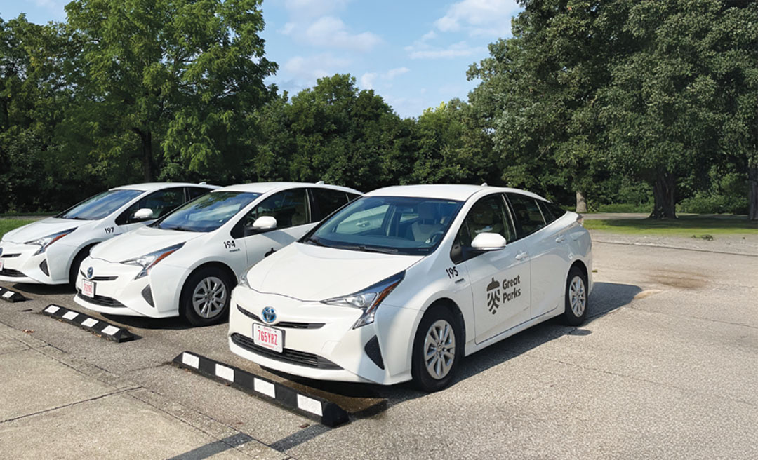 a group of white cars parked in a parking lot
