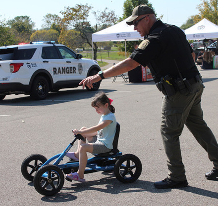 a man pushing a child on a tricycle